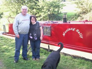 Alan and Sue Randles alongside canal boat with dog